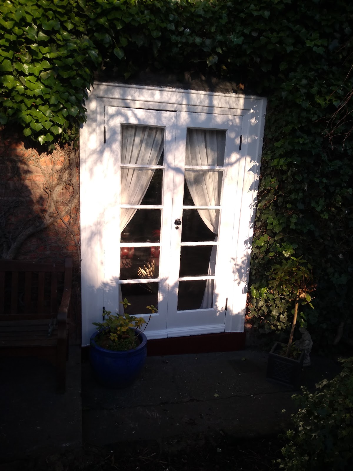 White painted French doors framed by ivy