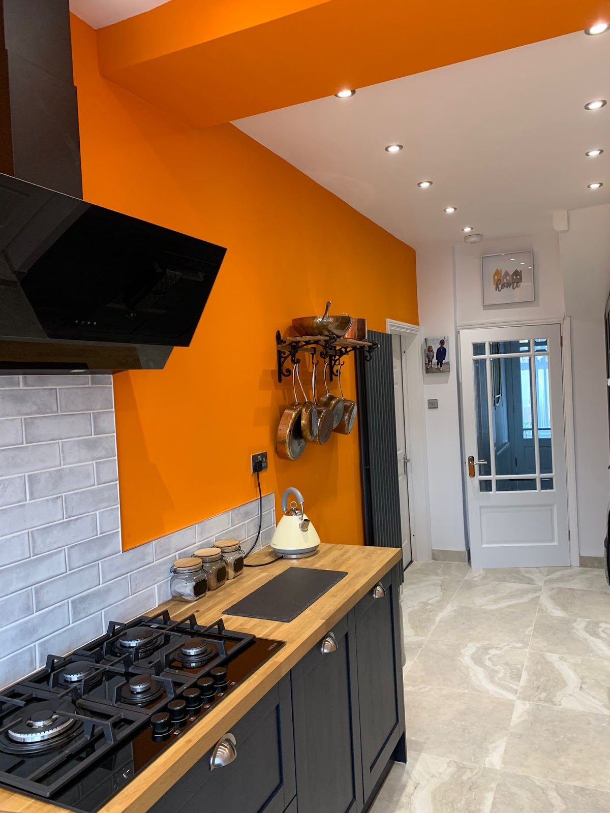 Kitchen with a bold orange feature wall and white ceiling